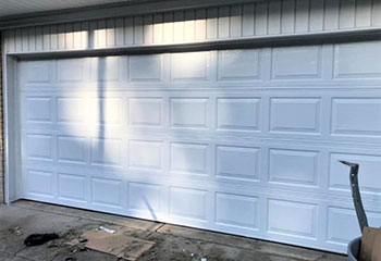 Broken garage door off its tracks showing urgent replacement need in South San Francisco